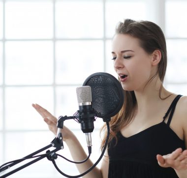 woman singing into microphone in studio