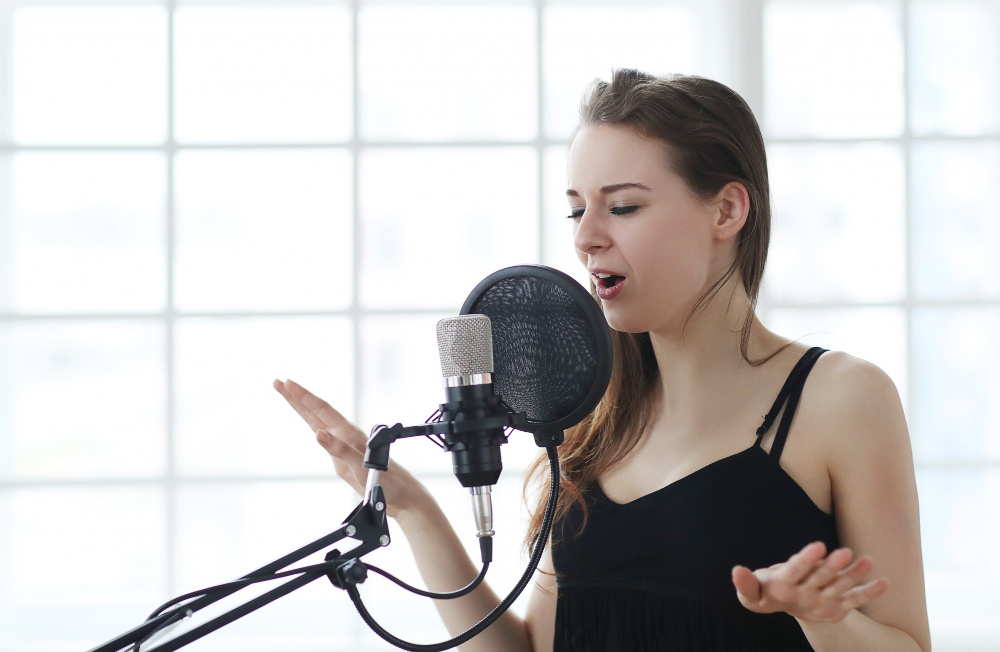 woman singing into microphone in studio